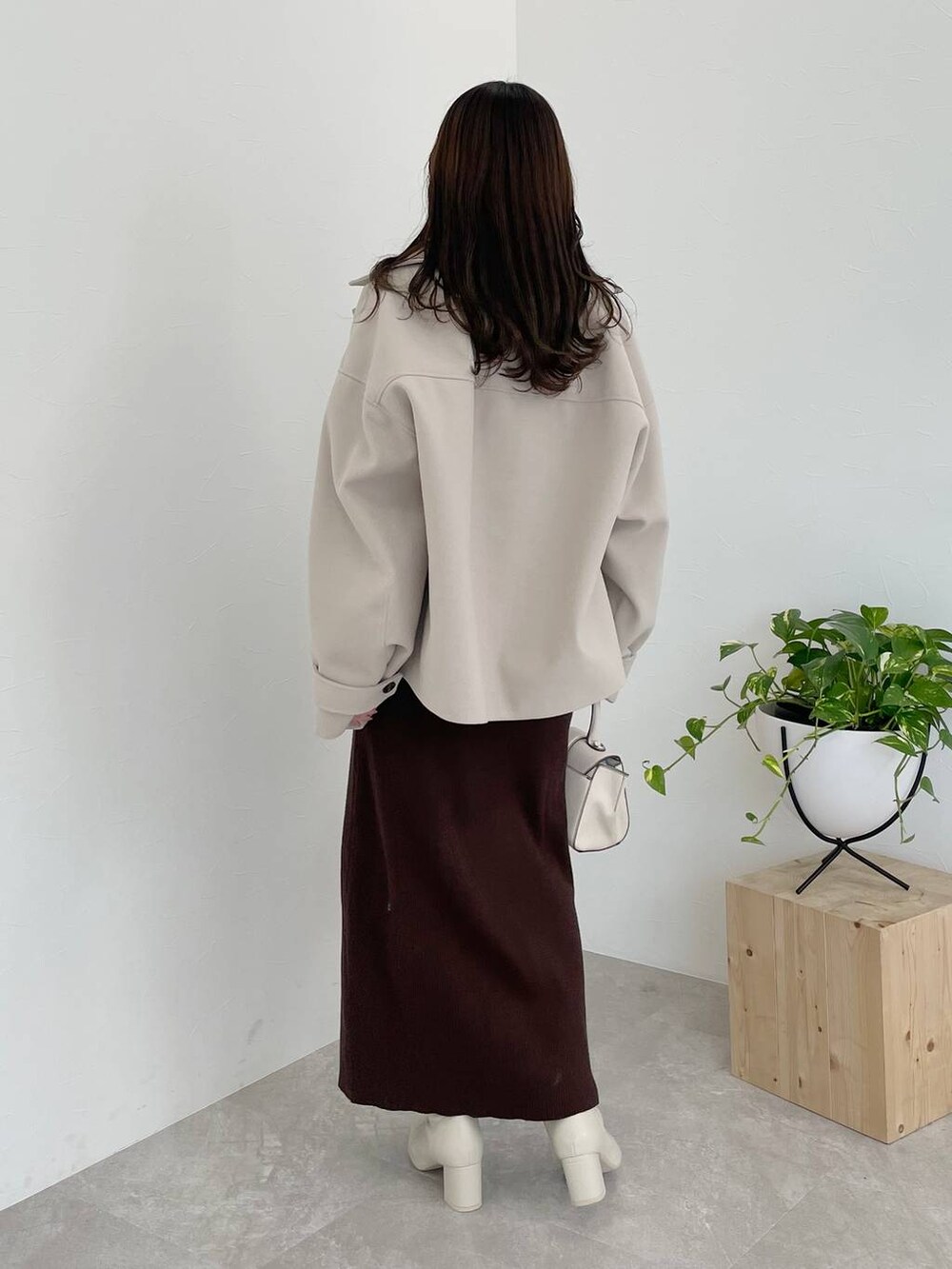 ホワイト系のその他アウター、ホワイト系のハンドバッグ、ホワイト系のブーツを着用したレディースの冬コーディネートの6枚目の写真