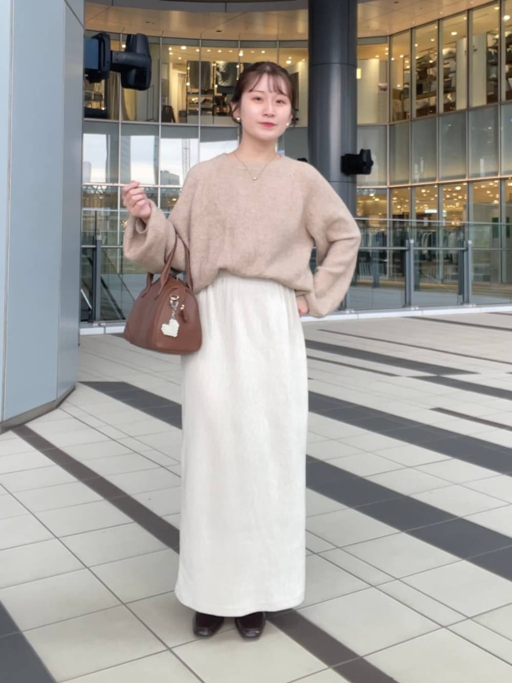 ベージュ系のニット/セーター、ホワイト系のブルゾンを着用したレディースの秋コーディネートの4枚目の写真