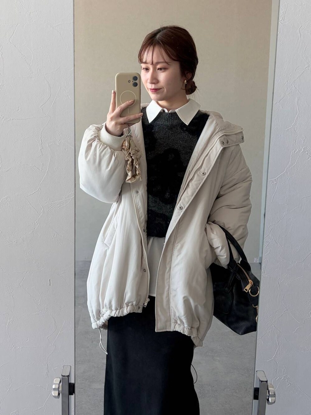 グレー系のニット/セーター、ブラック系のボストンバッグ、ブラック系のスカートを着用したレディースの冬コーディネートの3枚目の写真