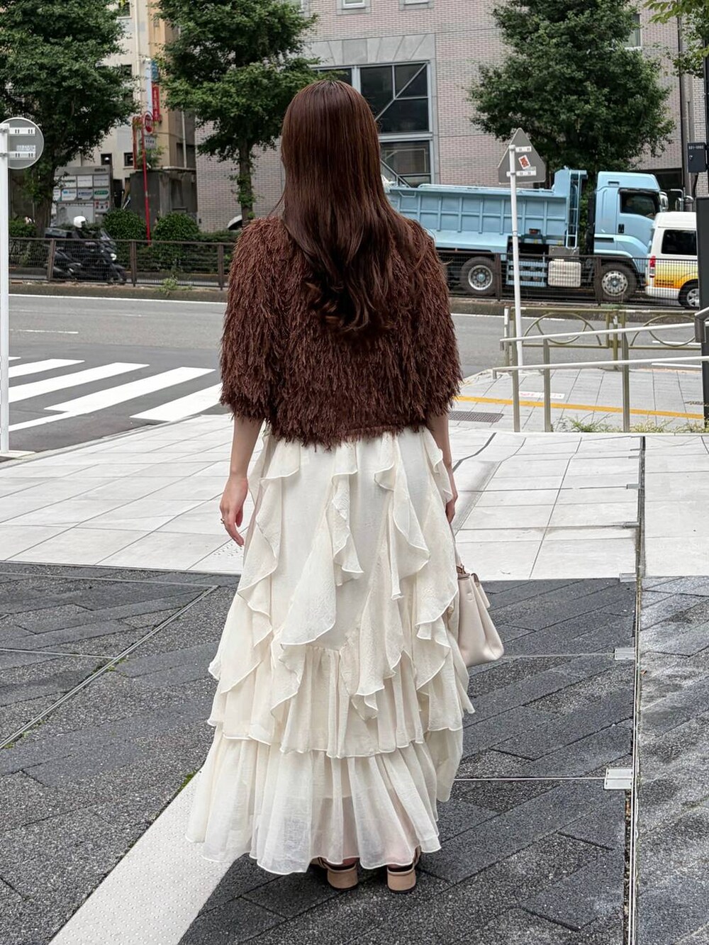 ベージュ系のサンダル、ホワイト系のスカート、ブラウン系のカーディガン/ボレロを着用したレディースの夏コーディネートの2枚目の写真