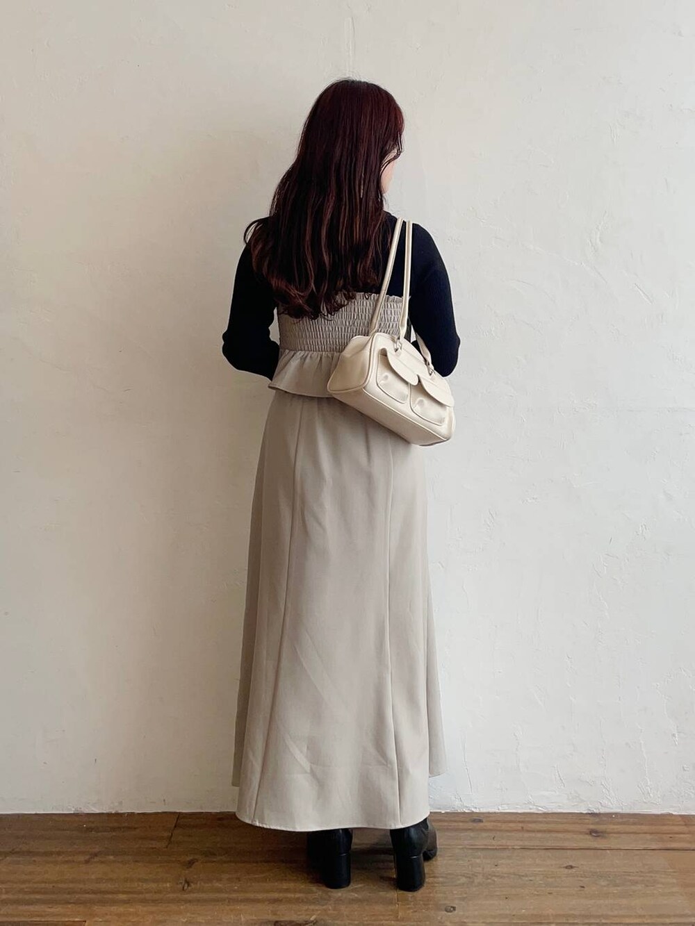 ブラック系のブルゾン、ブラック系のブーツ、ベージュ系のスカートを着用したレディースの秋コーディネートの4枚目の写真