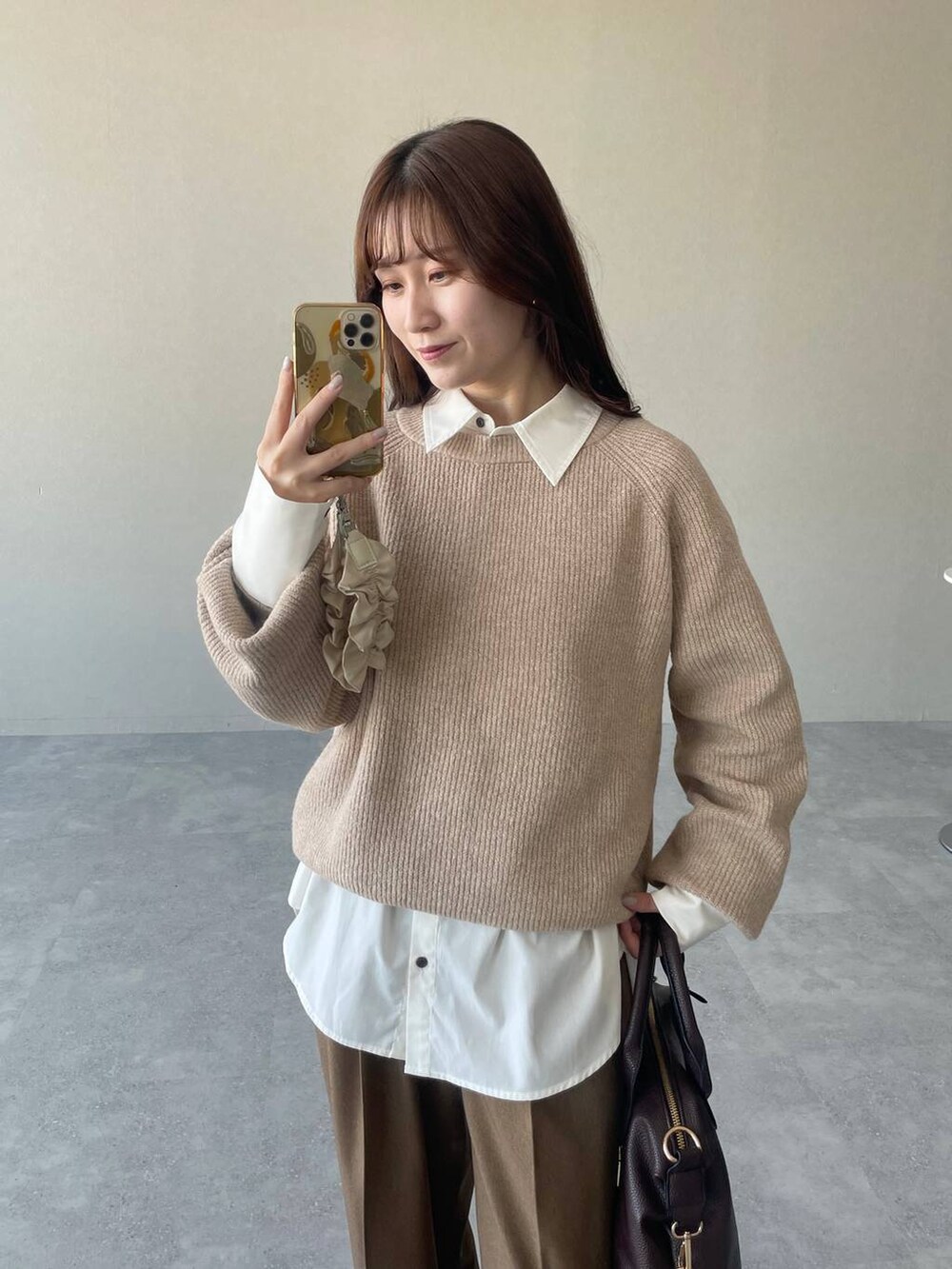 ベージュ系のピーコート、ベージュ系のニット/セーター、ブラウン系のボストンバッグを着用したレディースの冬コーディネートの4枚目の写真