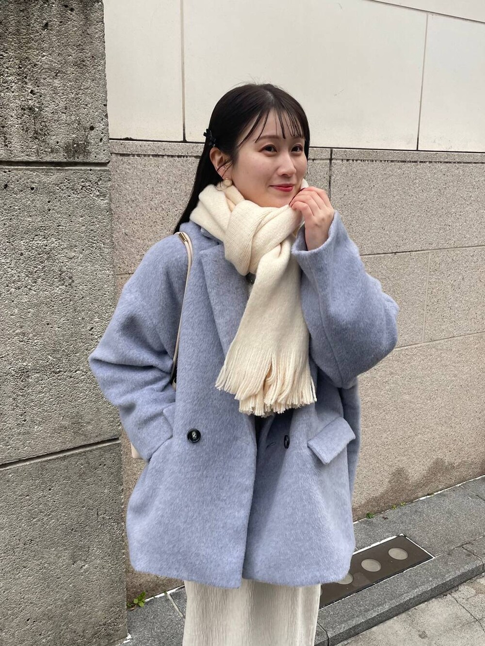 ホワイト系のスカート、グレー系のテーラードジャケット、ホワイト系のマフラーを着用したレディースの冬コーディネートの4枚目の写真