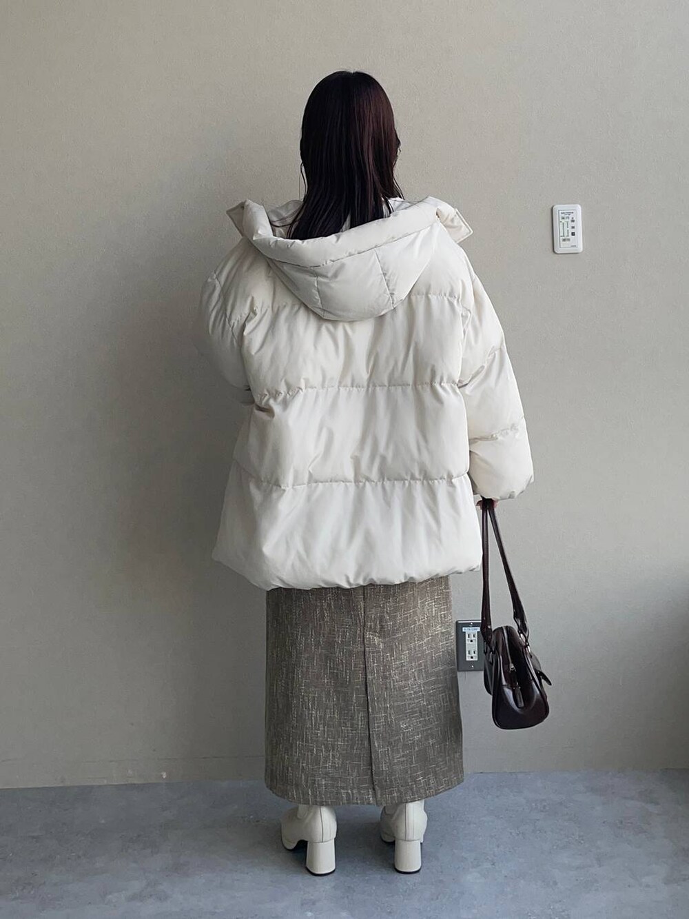 ホワイト系のブーツ、ホワイト系のカーディガン/ボレロ、ホワイト系のハンドバッグを着用したレディースの秋コーディネートの2枚目の写真