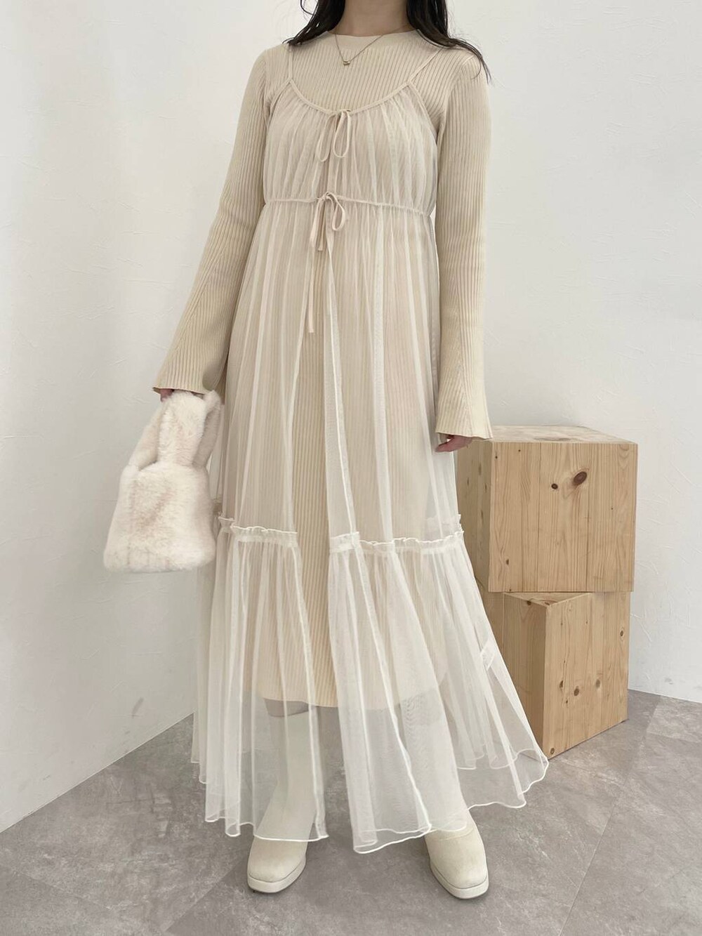 ホワイト系のブーツ、ホワイト系のハンドバッグ、ブラウン系のチェスターコートを着用したレディースの秋コーディネートの8枚目の写真