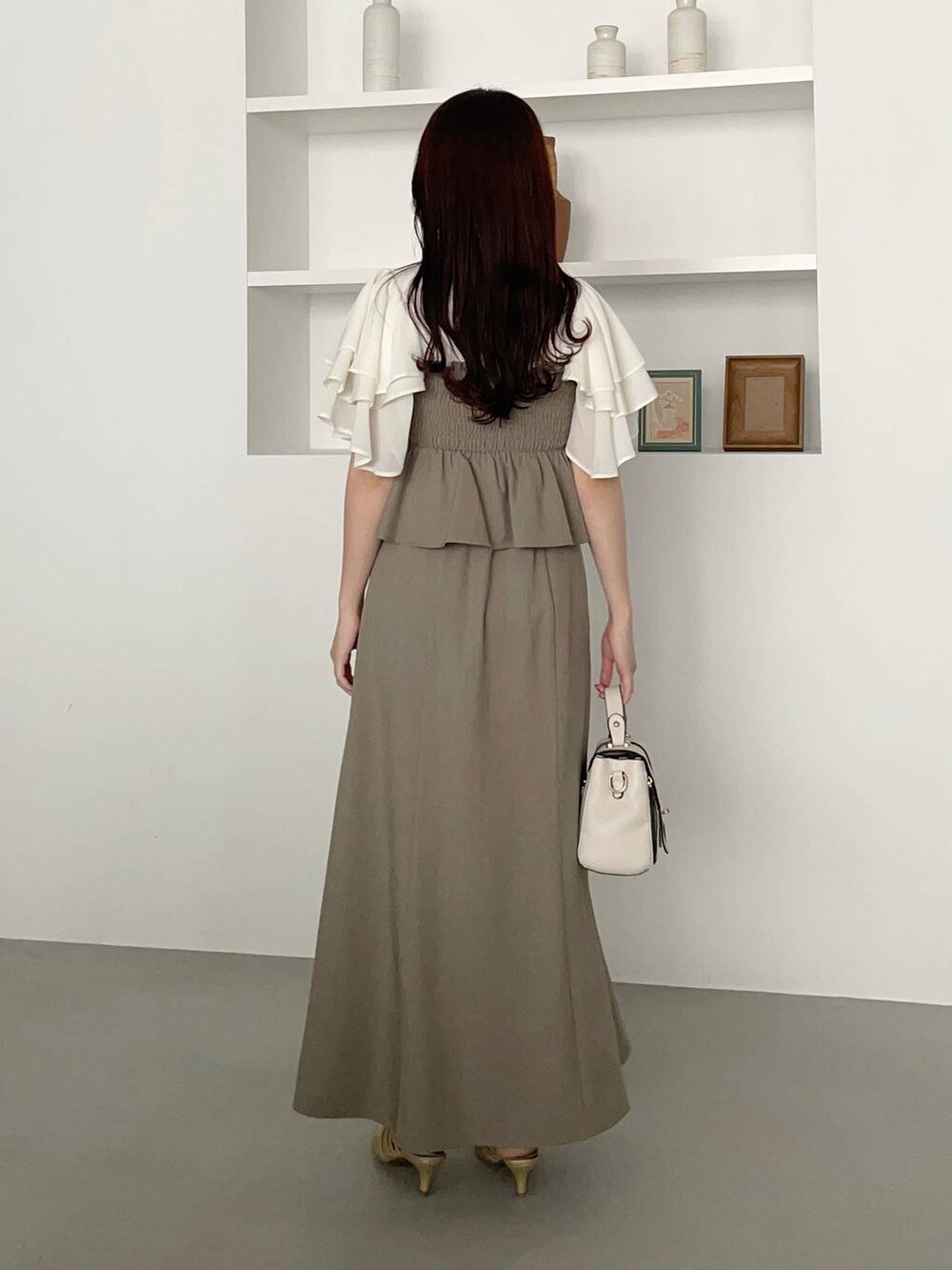 ゴールド系のパンプス、ホワイト系のショルダーバッグ、ホワイト系のTシャツ/カットソーを着用したレディースの春コーディネートの3枚目の写真