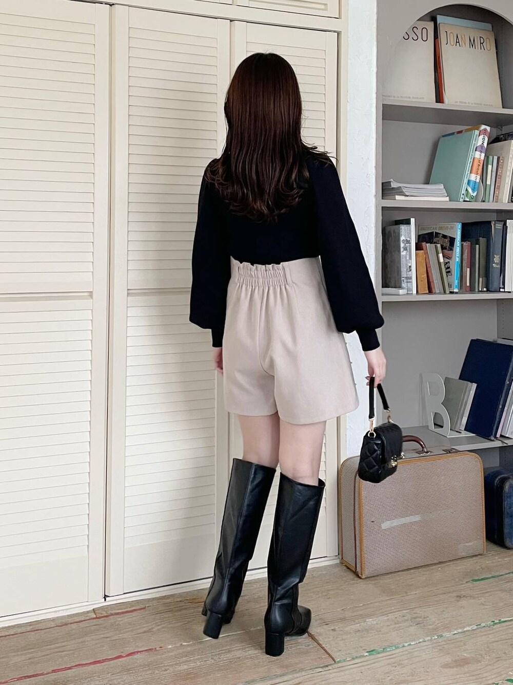 ブラック系のブーツ、ブラック系のニット/セーター、ベージュ系のその他パンツを着用したレディースの冬コーディネートの2枚目の写真