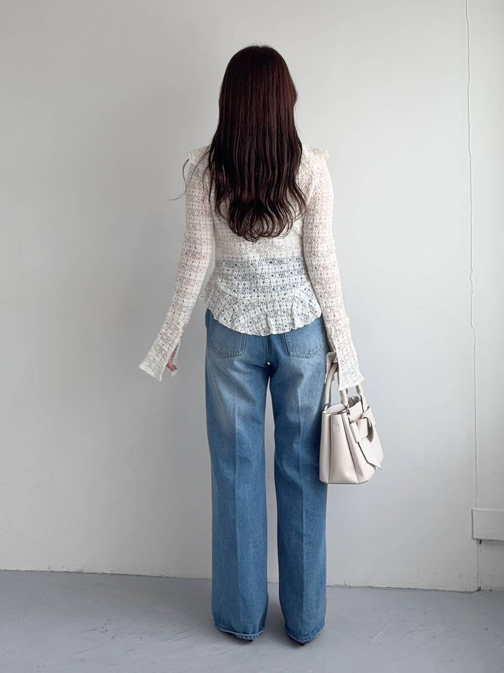 ホワイト系のシャツ/ブラウス、ブルー系のデニムパンツ、ホワイト系のショルダーバッグを着用したレディースの秋コーディネートの2枚目の写真