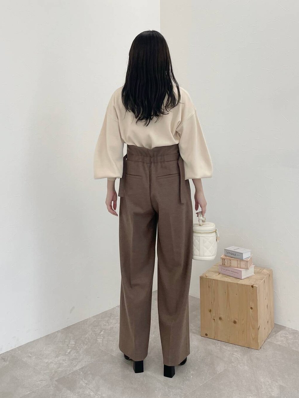 ベージュ系のその他パンツ、ブラック系のブーツ、ホワイト系のニット/セーターを着用したレディースの冬コーディネートの2枚目の写真