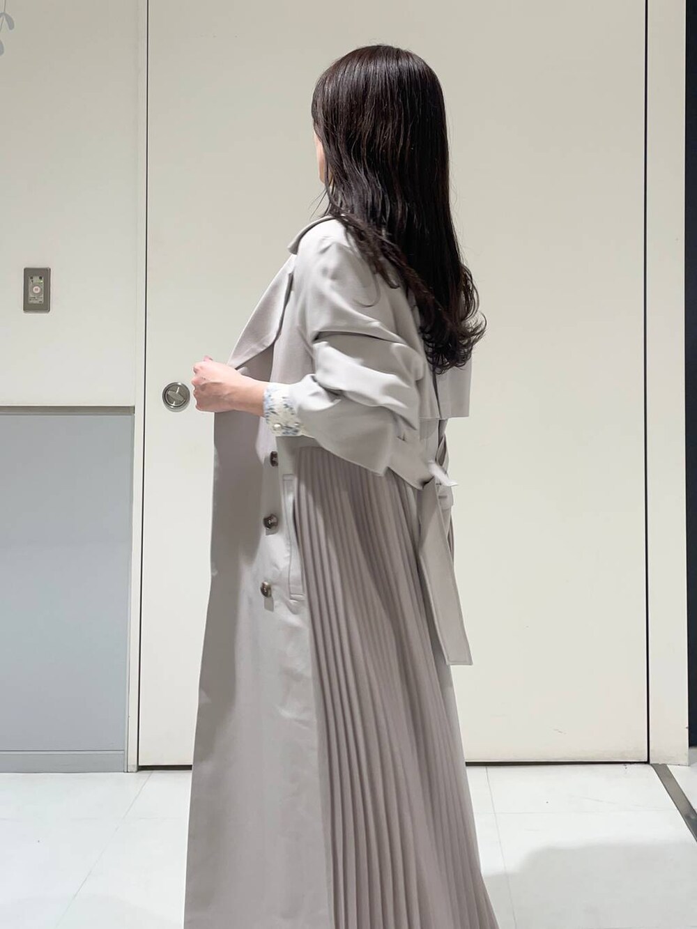 ブルー系のワンピース、ホワイト系のブーツ、グレー系のトレンチコートを着用したレディースの春コーディネートの4枚目の写真