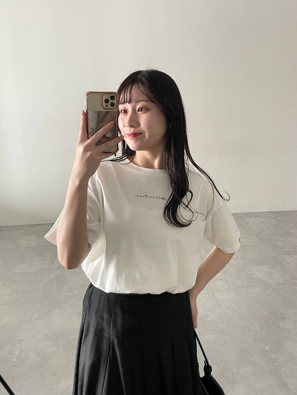 ブラック系のハンドバッグ、ホワイト系のサンダル、ブラック系のスカートを着用したレディースの春コーディネートの3枚目の写真