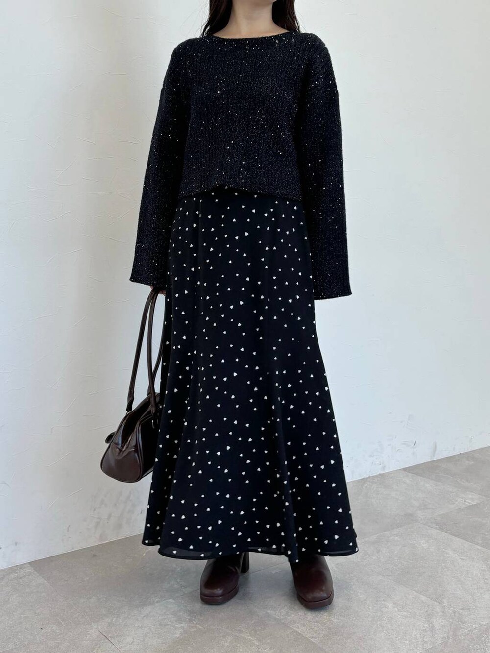 ブラウン系のブーツ、ブラウン系のハンドバッグ、ブラック系のスカートを着用したレディースの冬コーディネートの4枚目の写真