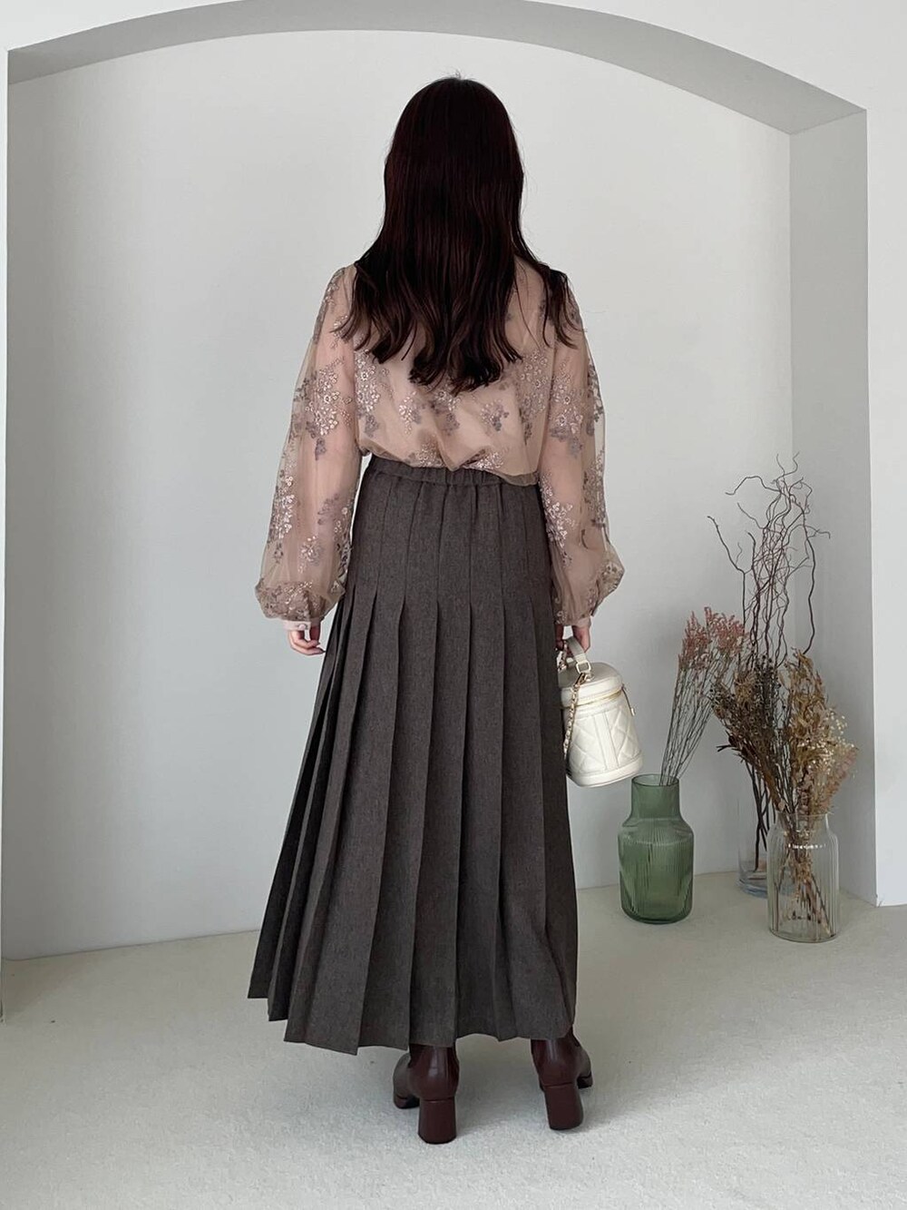 ピンク系のシャツ/ブラウス、ブラウン系のブーツ、ホワイト系のショルダーバッグを着用したレディースの冬コーディネートの2枚目の写真