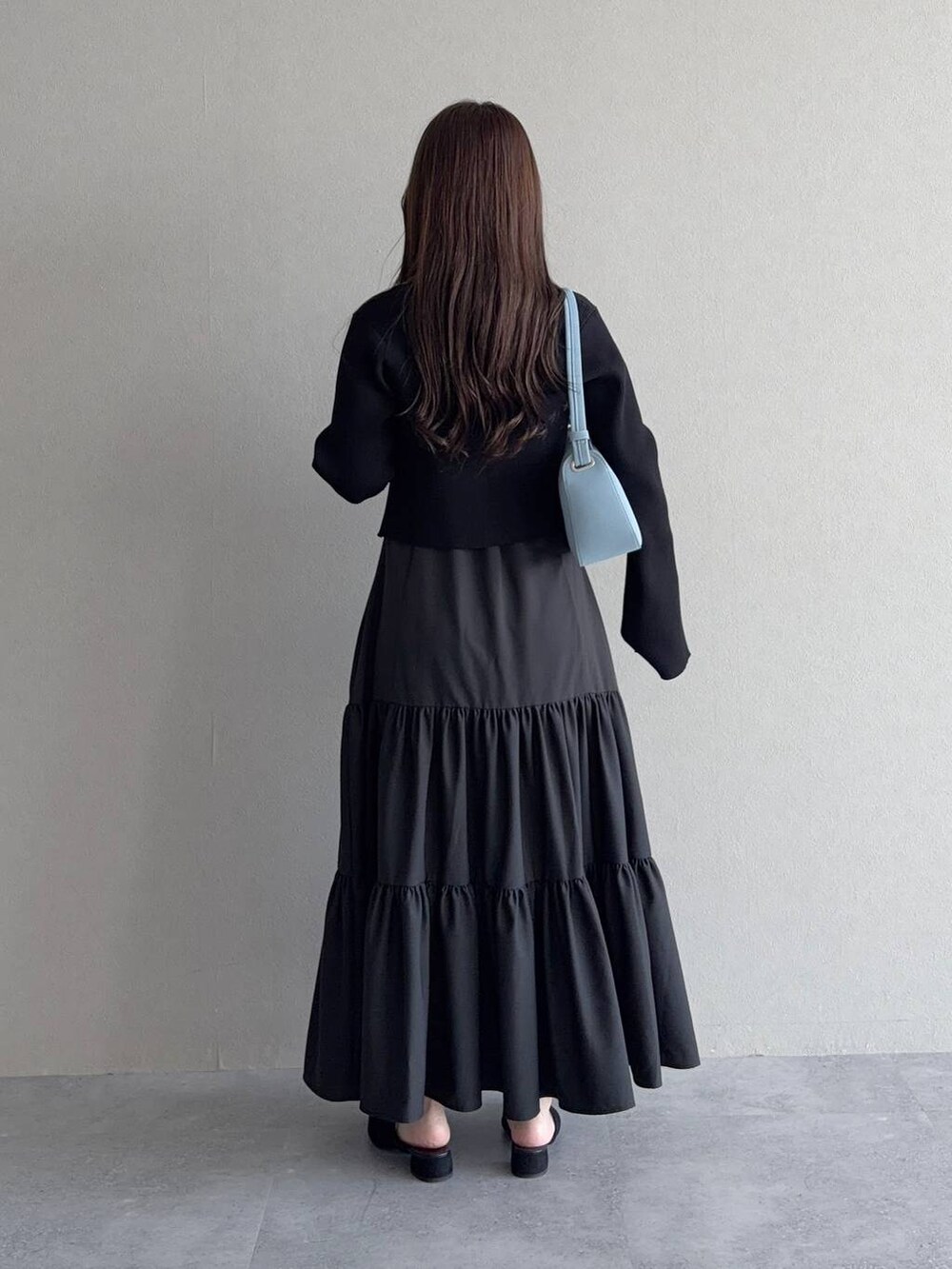 ブラック系のサンダル、ブラック系のワンピース、ブルー系のショルダーバッグを着用したレディースの夏コーディネートの2枚目の写真
