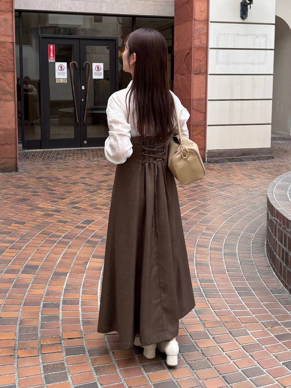 ブラウン系のワンピースを着用したレディースの秋コーディネートの2枚目の写真