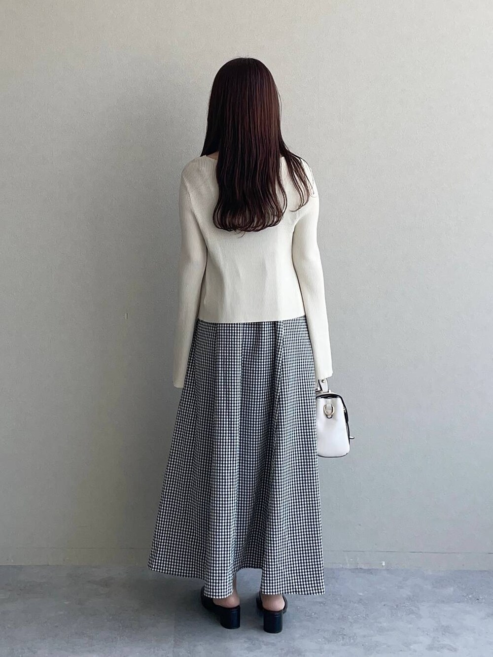 ホワイト系のショルダーバッグ、ブラック系のワンピース、ホワイト系のカーディガン/ボレロを着用したレディースの夏コーディネートの2枚目の写真