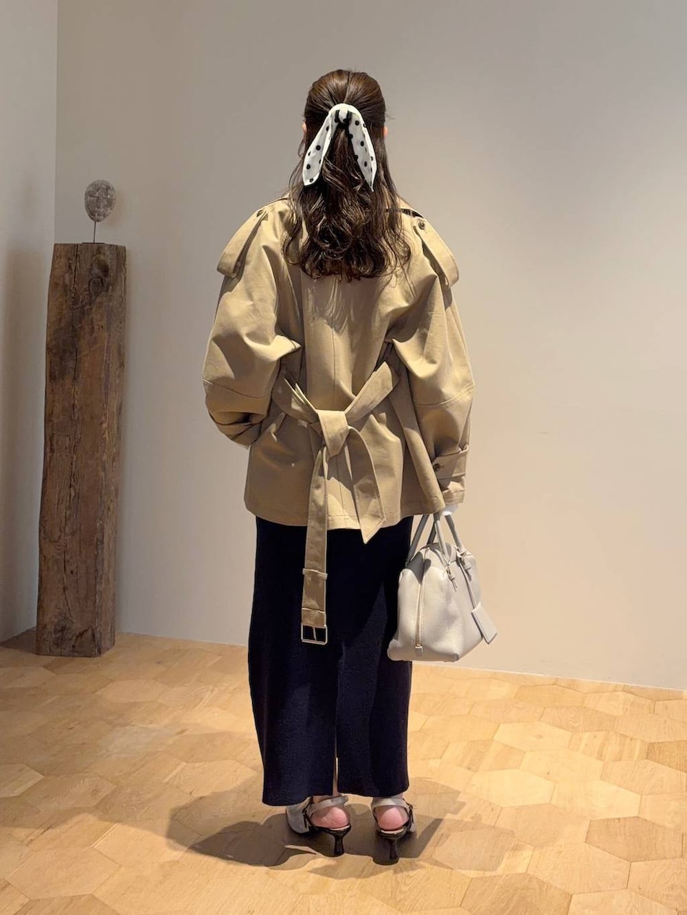 ベージュ系のハンドバッグ、ブルー系のワンピース、ホワイト系のサンダルを着用したレディースの冬コーディネートの2枚目の写真