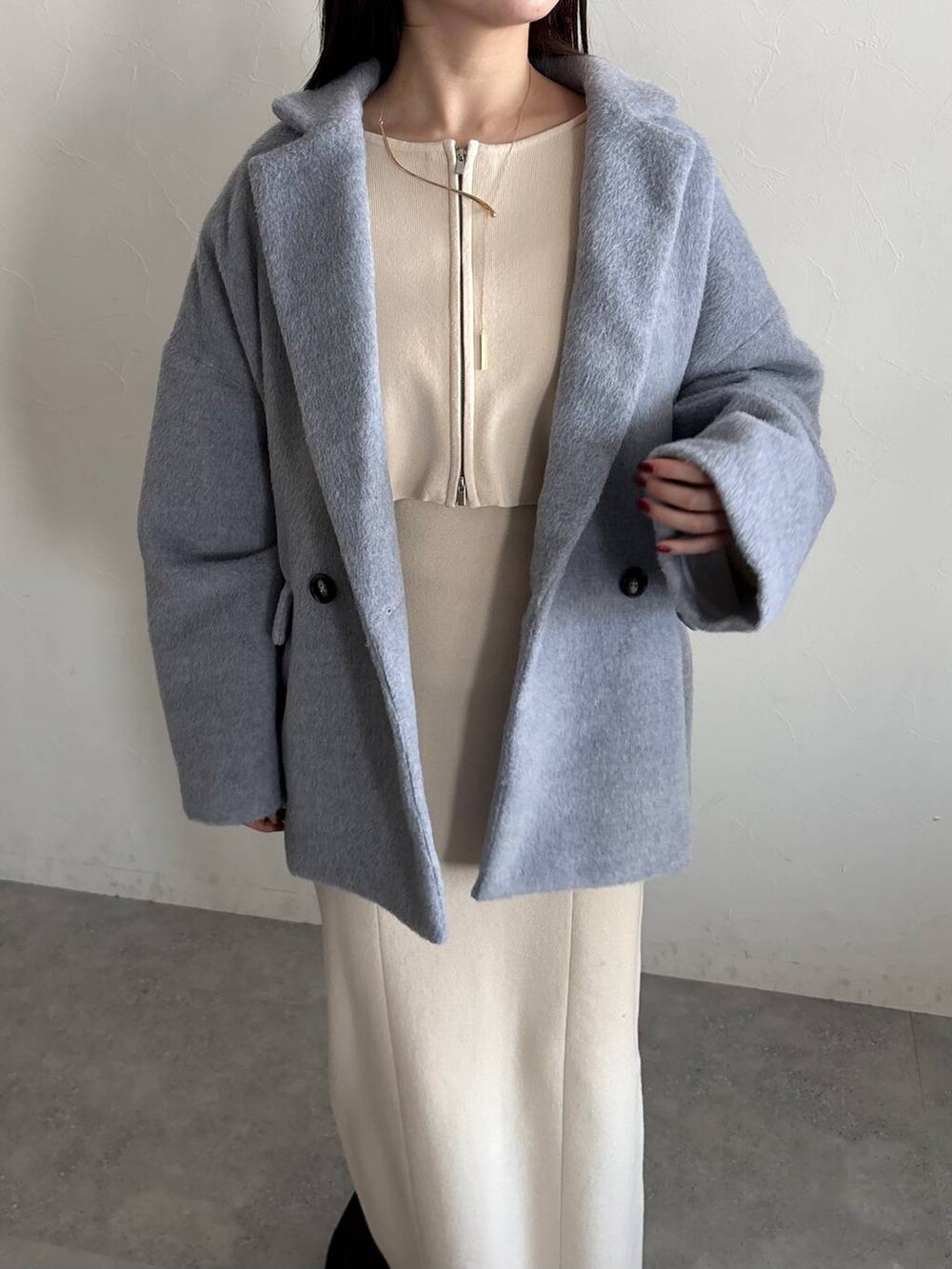 ブラック系のショルダーバッグ、ブラック系のブーツ、ホワイト系のワンピースを着用したレディースの冬コーディネートの3枚目の写真