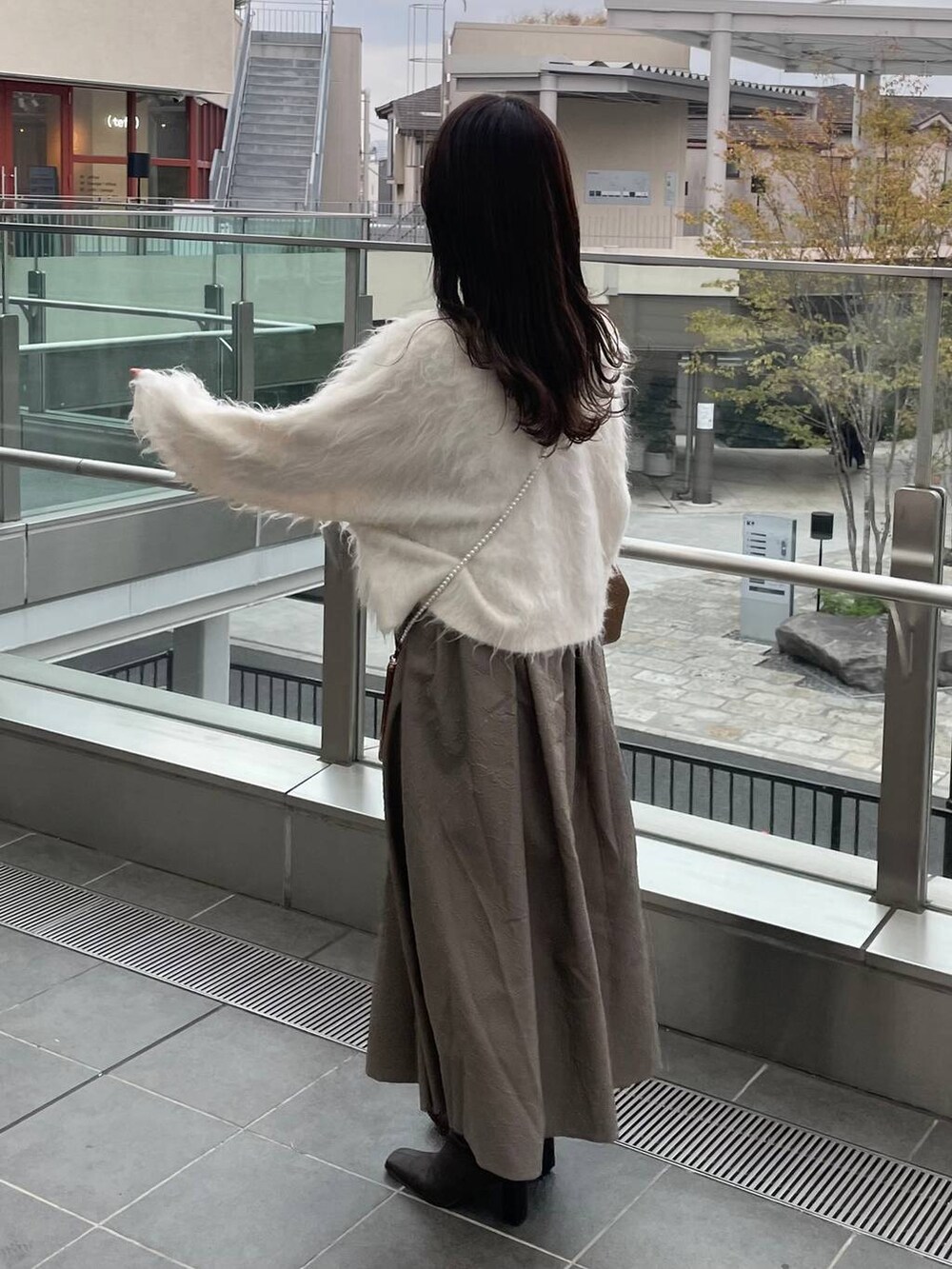 グリーン系のTシャツ/カットソー、ホワイト系のカーディガン/ボレロを着用したレディースの秋コーディネートの2枚目の写真