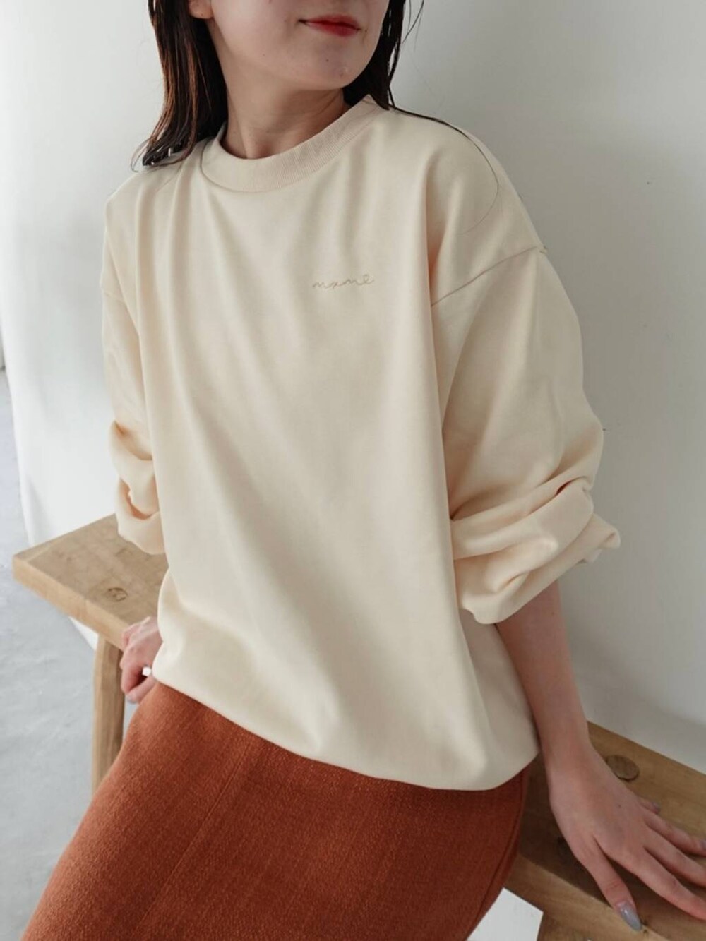 ブラウン系のブーツ、オレンジ系のスカート、ホワイト系のスウェットを着用したレディースの秋コーディネートの4枚目の写真