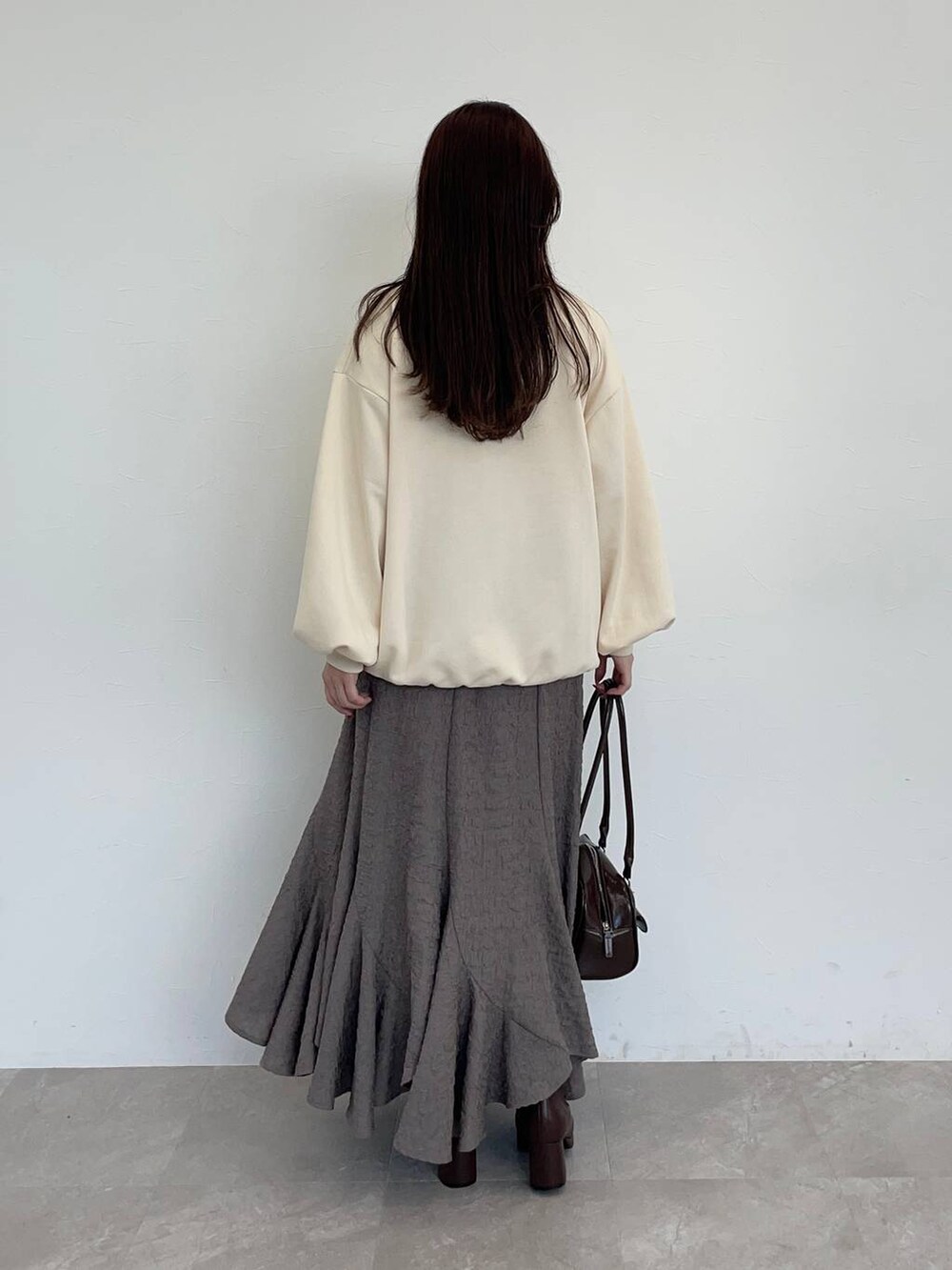 ブラウン系のブーツ、ホワイト系のスウェット、ブラウン系のスカートを着用したレディースの秋コーディネートの4枚目の写真