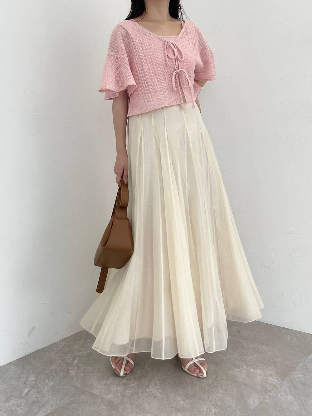 ブラウン系のショルダーバッグ、ホワイト系のサンダル、ホワイト系のスカートを着用したレディースの夏コーディネートの4枚目の写真