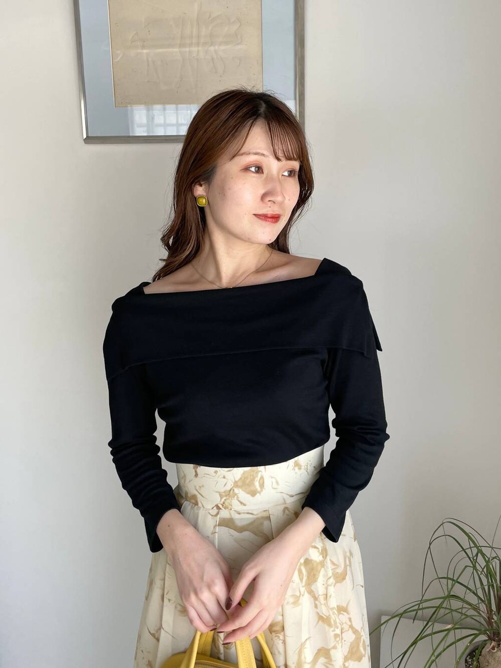 イエロー系のスカート、イエロー系のボストンバッグ、ブラック系のTシャツ/カットソーを着用したレディースの夏コーディネートの3枚目の写真