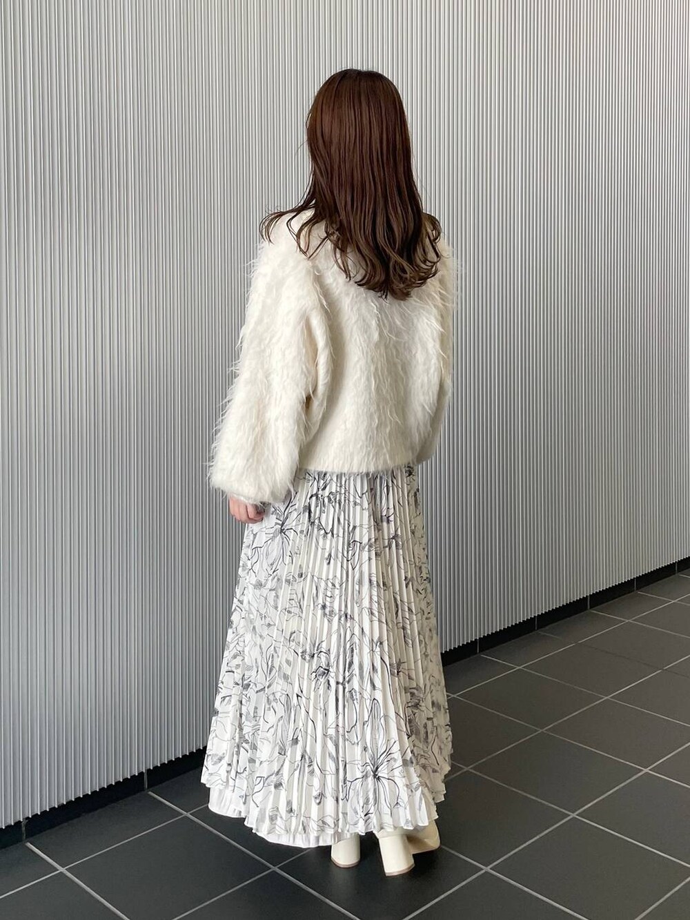 ホワイト系のカーディガン/ボレロ、ホワイト系のブーツ、オレンジ系のショルダーバッグを着用したレディースの秋コーディネートの3枚目の写真