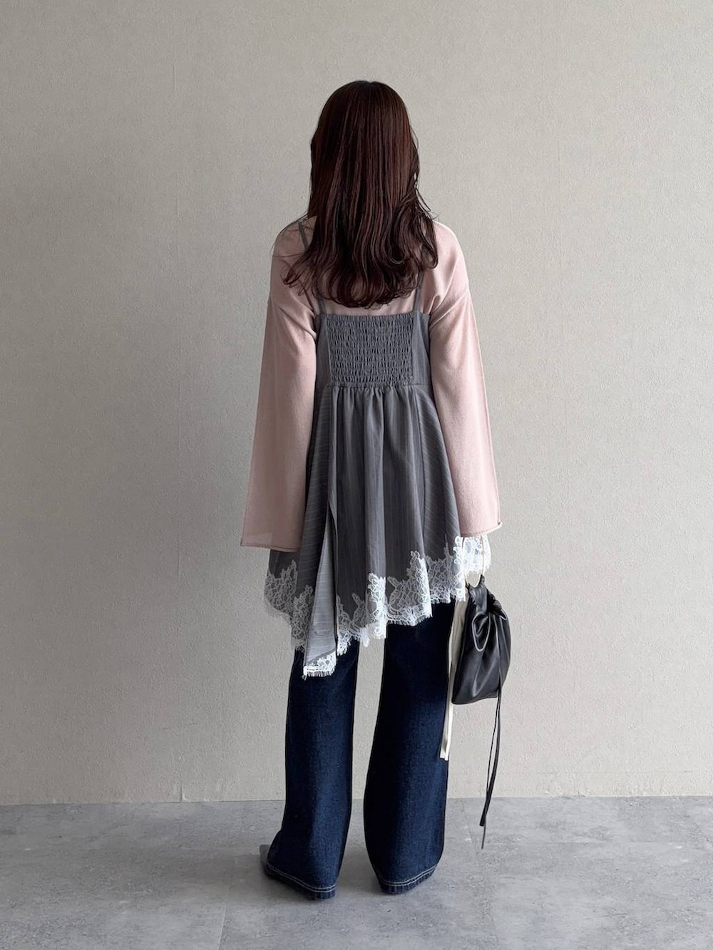 ベージュ系のニット/セーター、ブルー系のデニムパンツ、ブラック系のサンダルを着用したレディースの春コーディネートの2枚目の写真