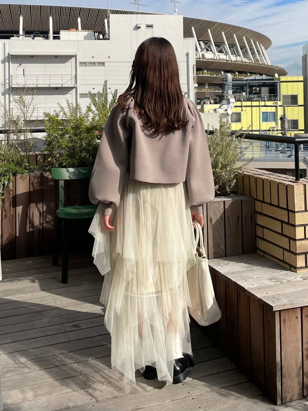 ベージュ系のカーディガン/ボレロ、ホワイト系のトートバッグ、ホワイト系のスカートを着用したレディースの冬コーディネートの2枚目の写真