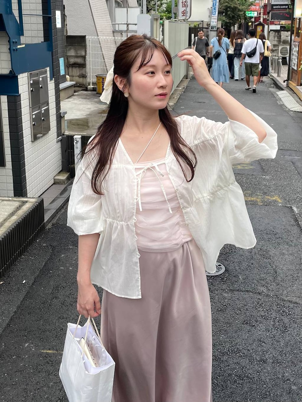 ベージュ系のスカート、ホワイト系のシャツ/ブラウス、ベージュ系のシュシュを着用したレディースの夏コーディネートの3枚目の写真