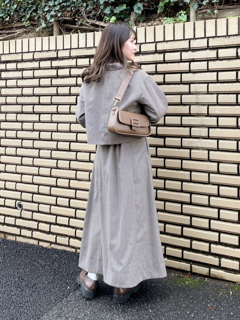 ブラウン系のテーラードジャケット、ピンク系のニット/セーター、ブラウン系のショルダーバッグを着用したレディースの冬コーディネートの3枚目の写真