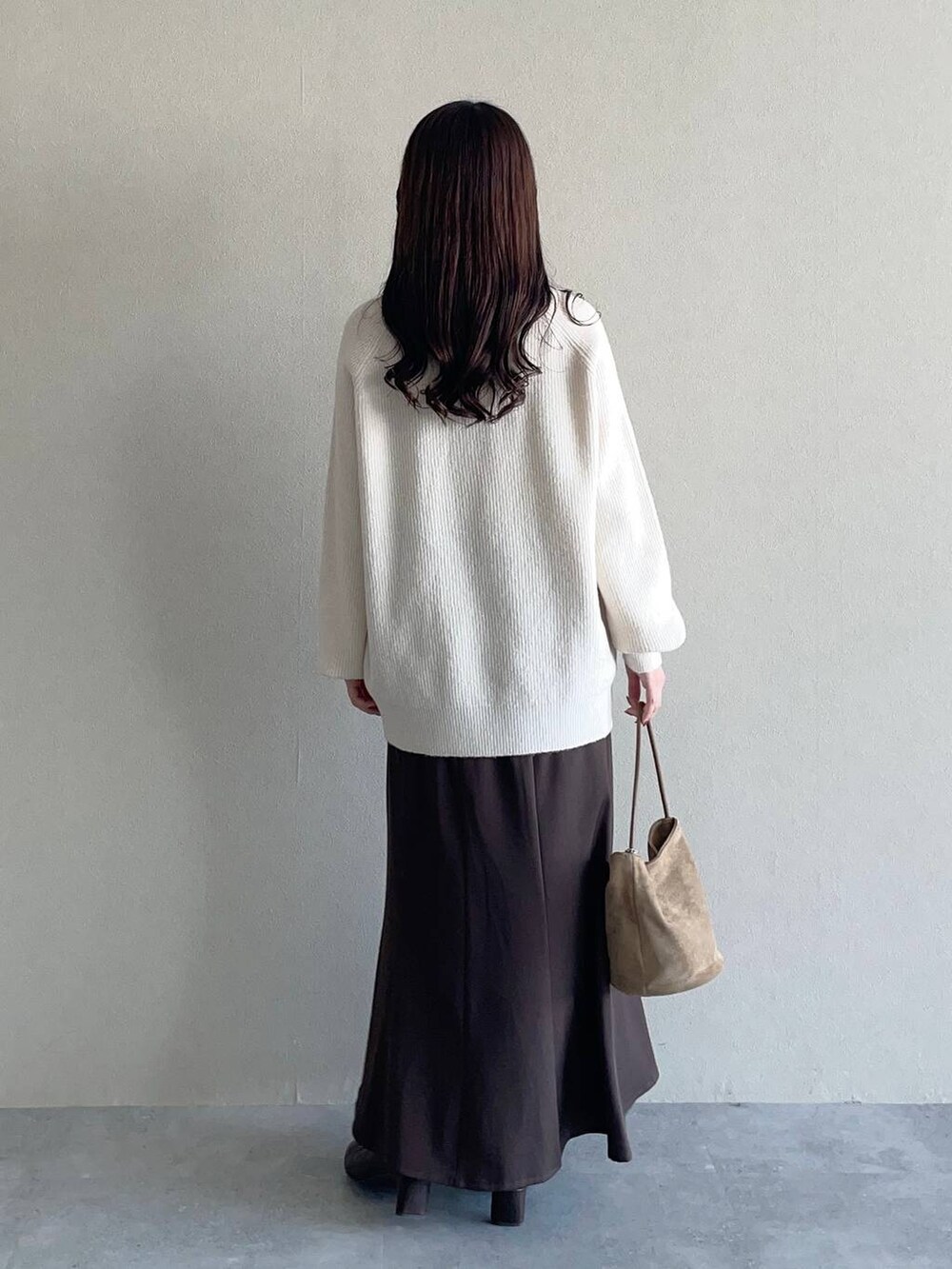 ブラウン系のスカート、ブラウン系のブルゾン、ホワイト系のニット/セーターを着用したレディースの秋コーディネートの4枚目の写真