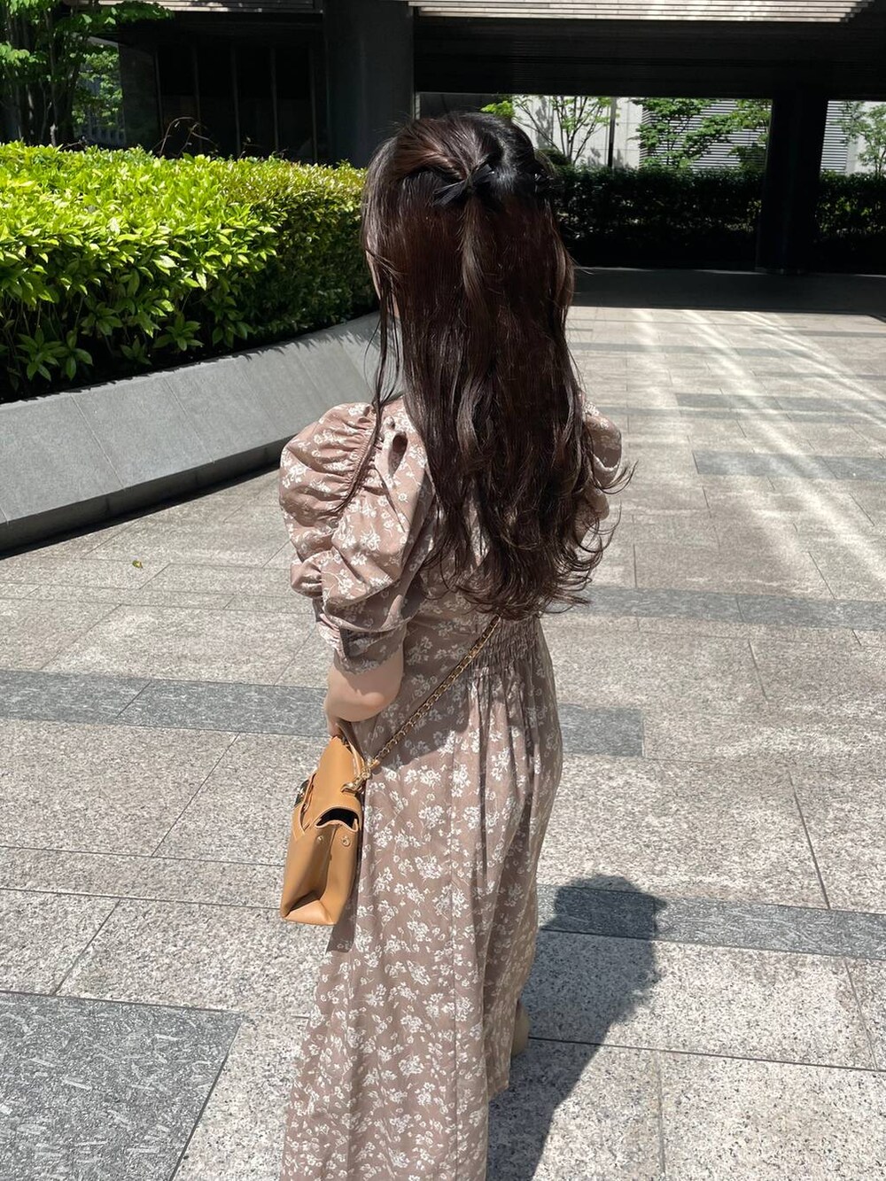 ブラウン系のショルダーバッグ、ベージュ系のワンピースを着用したレディースの春コーディネートの3枚目の写真