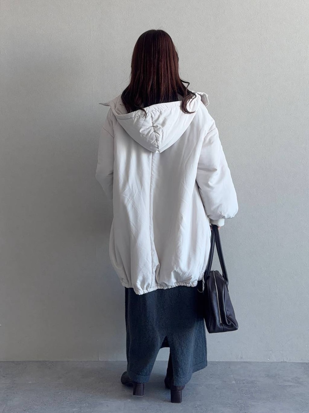 ブラウン系のブーツ、ブラウン系のトートバッグ、グレー系のワンピースを着用したレディースの冬コーディネートの2枚目の写真