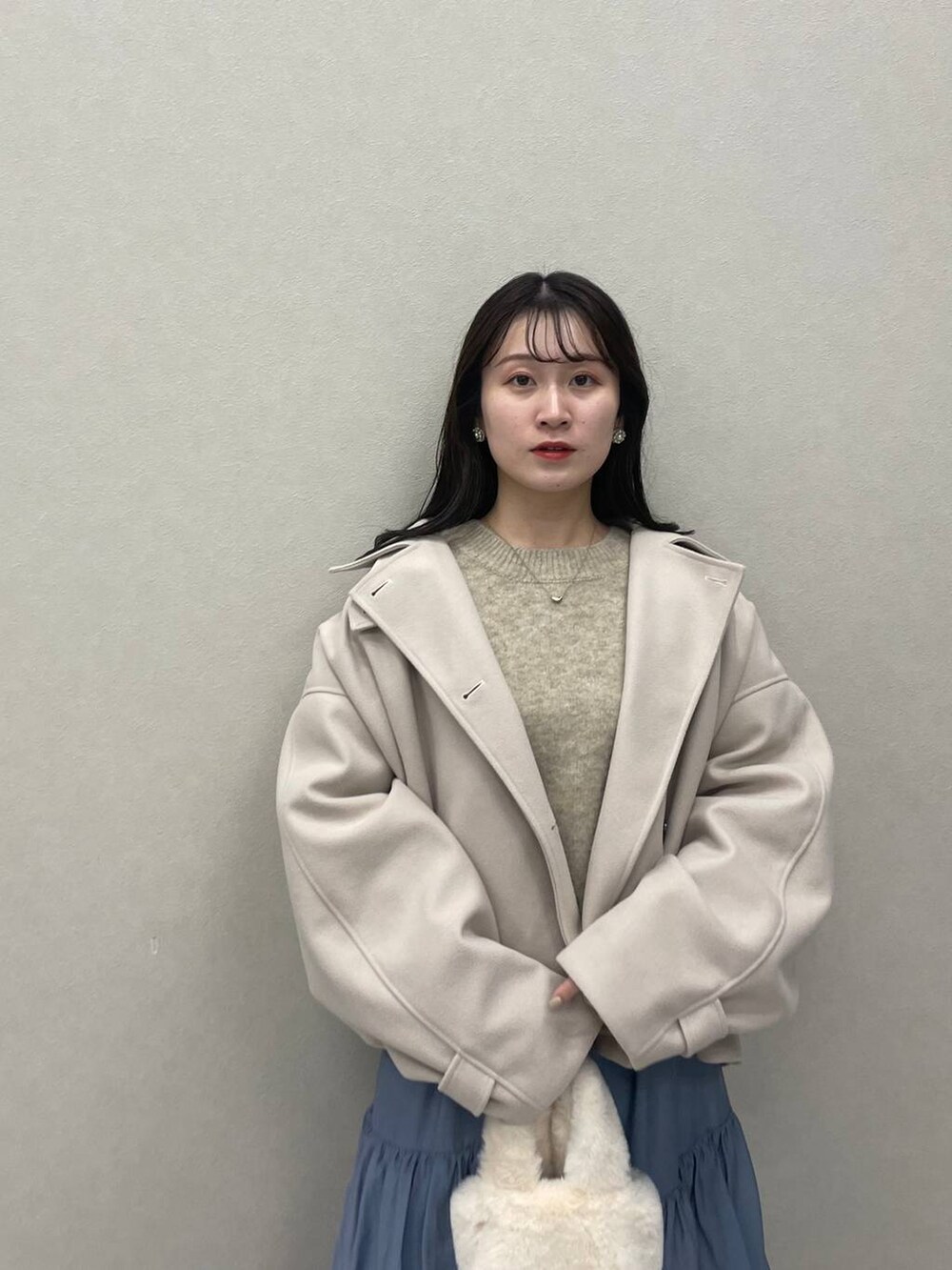 ホワイト系のその他アウター、ホワイト系のブーツ、ブルー系のスカートを着用したレディースの秋コーディネートの3枚目の写真