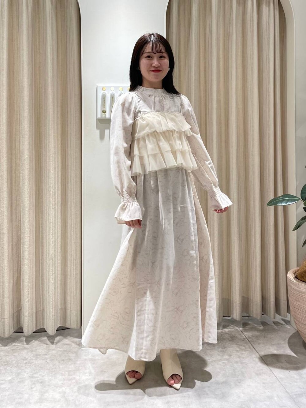 ホワイト系のブーツ、ベージュ系のワンピース、ホワイト系のブルゾンを着用したレディースの冬コーディネートの5枚目の写真