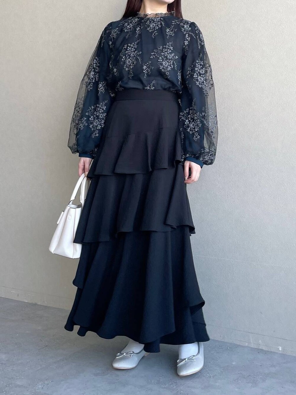 ブラック系のシャツ/ブラウス、ブラック系のスカート、ホワイト系のショルダーバッグを着用したレディースの冬コーディネートの4枚目の写真