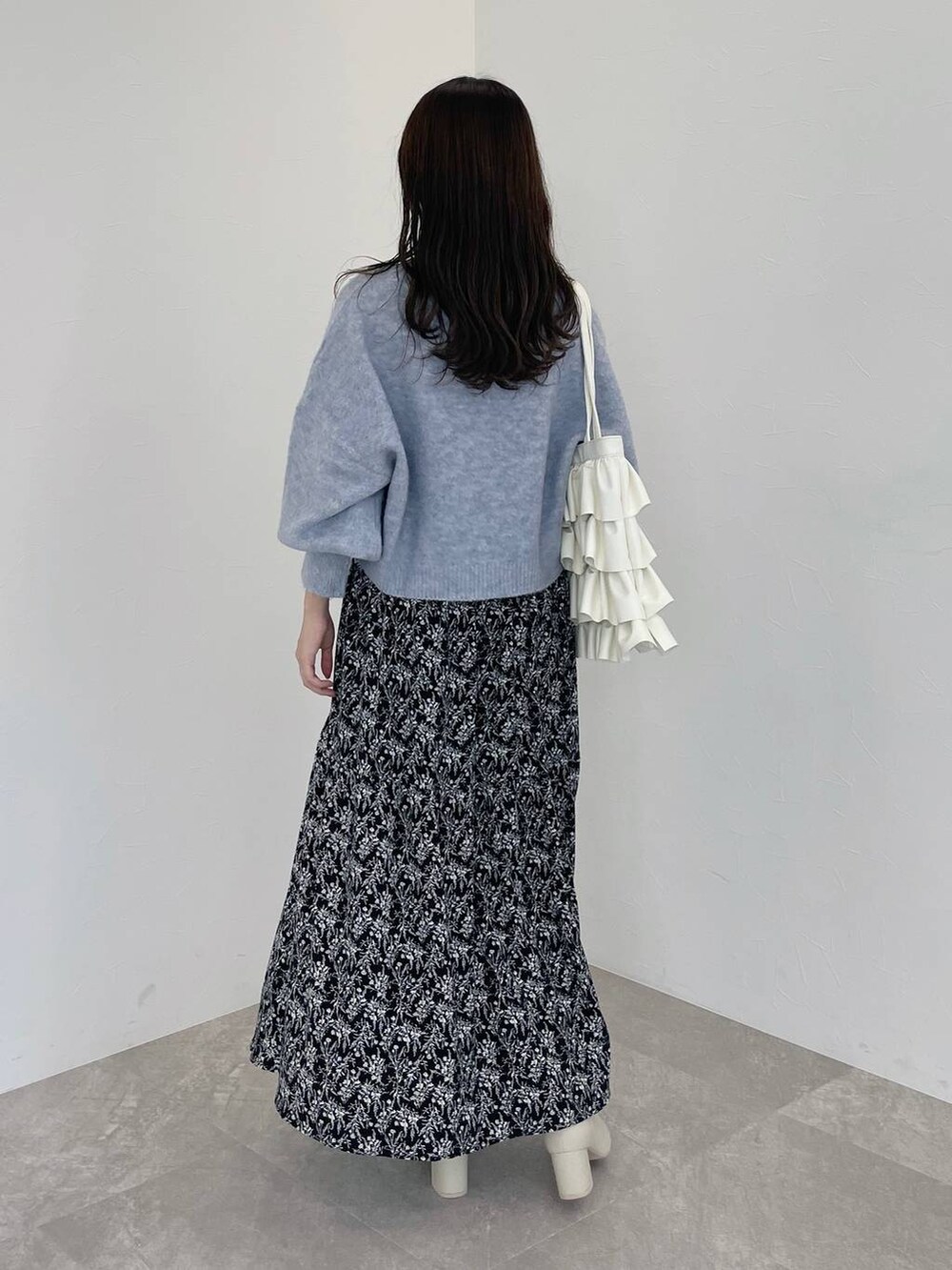 ホワイト系のブーツ、ブルー系のニット/セーター、ブラック系のワンピースを着用したレディースの秋コーディネートの3枚目の写真