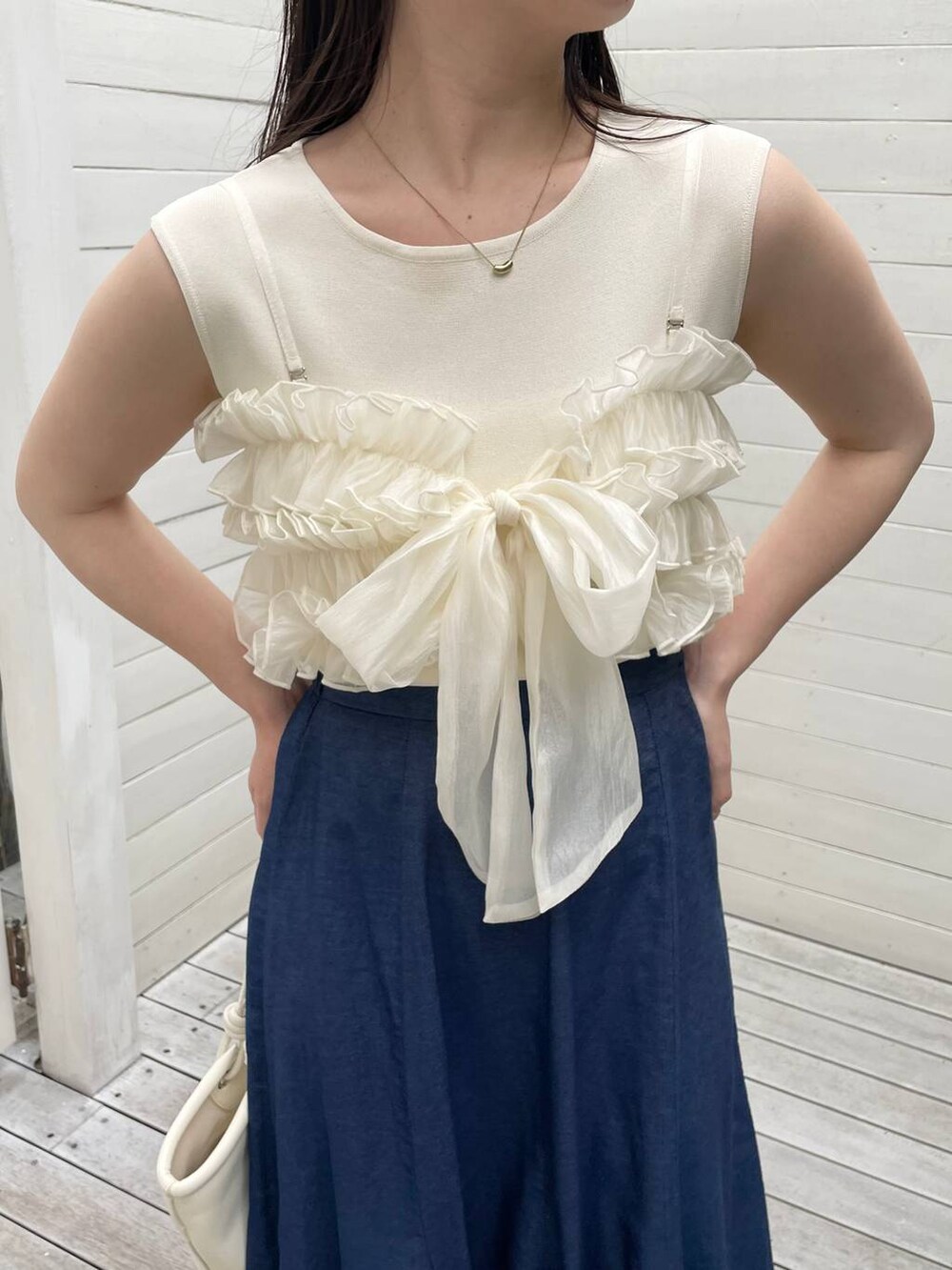 ホワイト系のハンドバッグ、ブルー系のスカート、ホワイト系のサンダルを着用したレディースの夏コーディネートの3枚目の写真