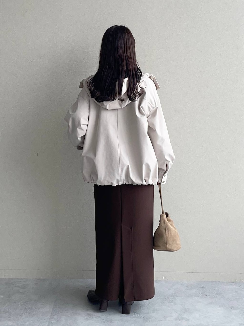 ベージュ系のニット/セーター、ベージュ系のマウンテンパーカー、ブラウン系のスカートを着用したレディースの秋コーディネートの2枚目の写真