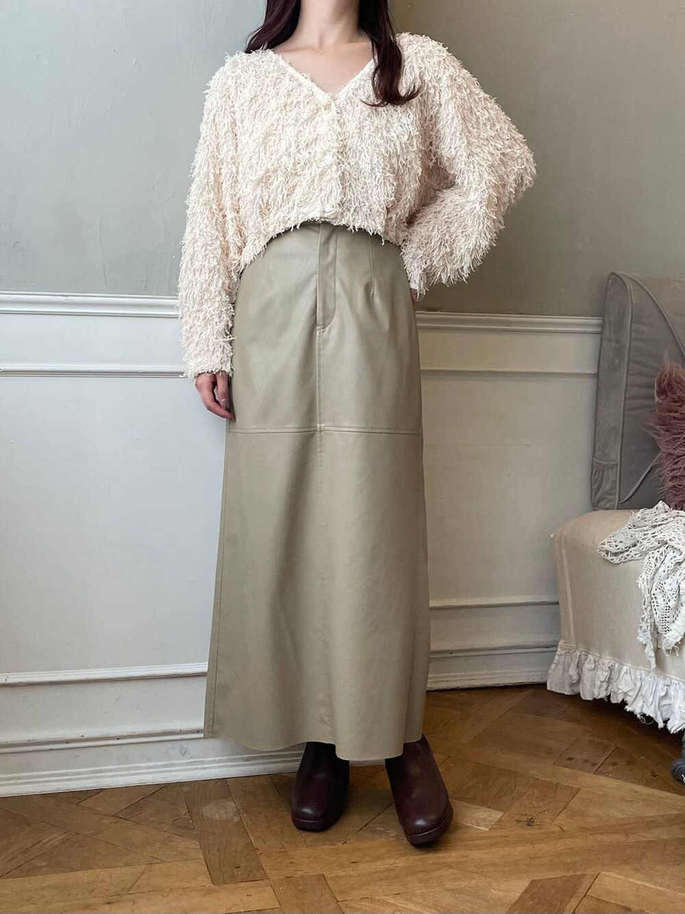 ブラウン系のブーツ、ベージュ系のスカート、ブラウン系のハンドバッグを着用したレディースの冬コーディネートの4枚目の写真