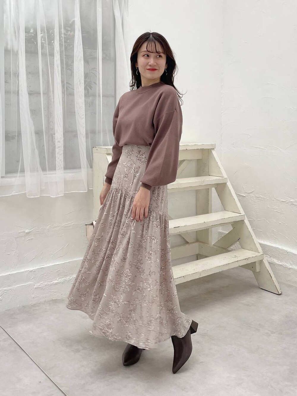 ホワイト系のハンドバッグ、ブラウン系のニット/セーター、ブラウン系のブーツを着用したレディースの秋コーディネートの4枚目の写真