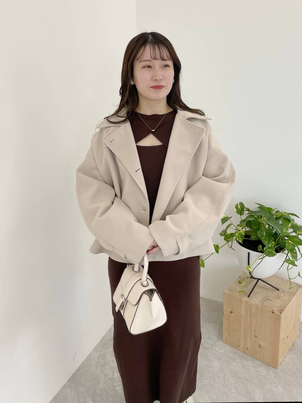 ホワイト系のその他アウター、ホワイト系のハンドバッグ、ホワイト系のブーツを着用したレディースの冬コーディネートの7枚目の写真