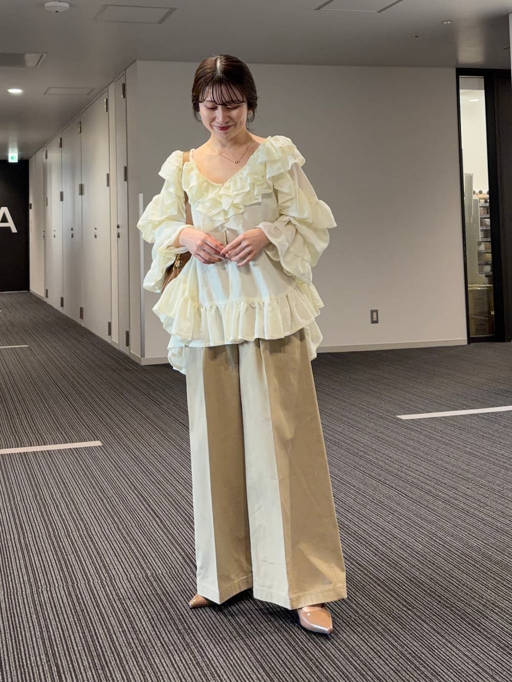 ブラウン系のサンダル、イエロー系のショルダーバッグ、ホワイト系のシャツ/ブラウスを着用したレディースの春コーディネートの2枚目の写真