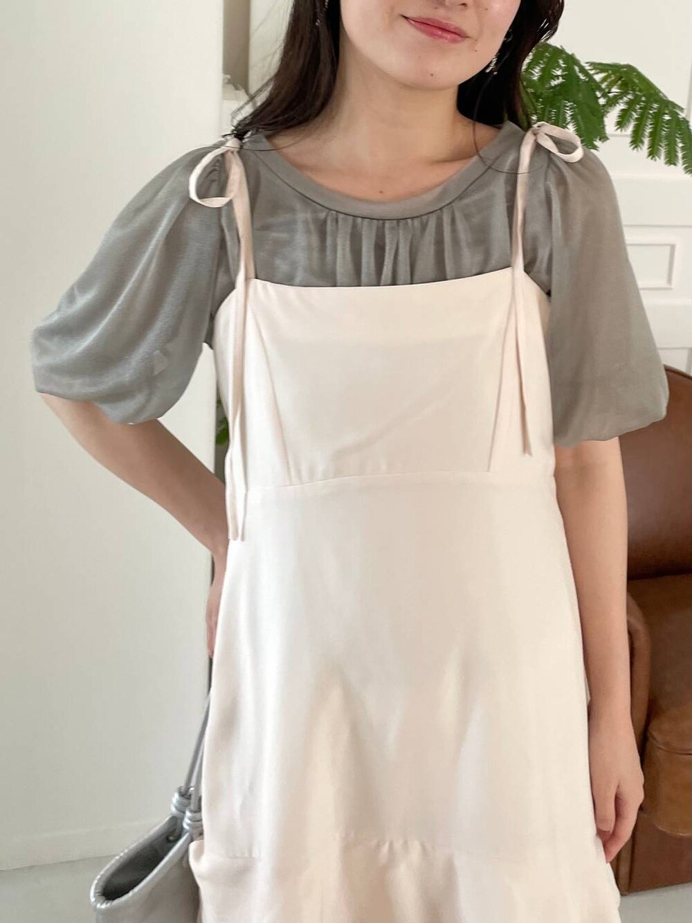 シルバー系のハンドバッグ、ホワイト系のサンダル、ホワイト系のワンピースを着用したレディースの夏コーディネートの3枚目の写真