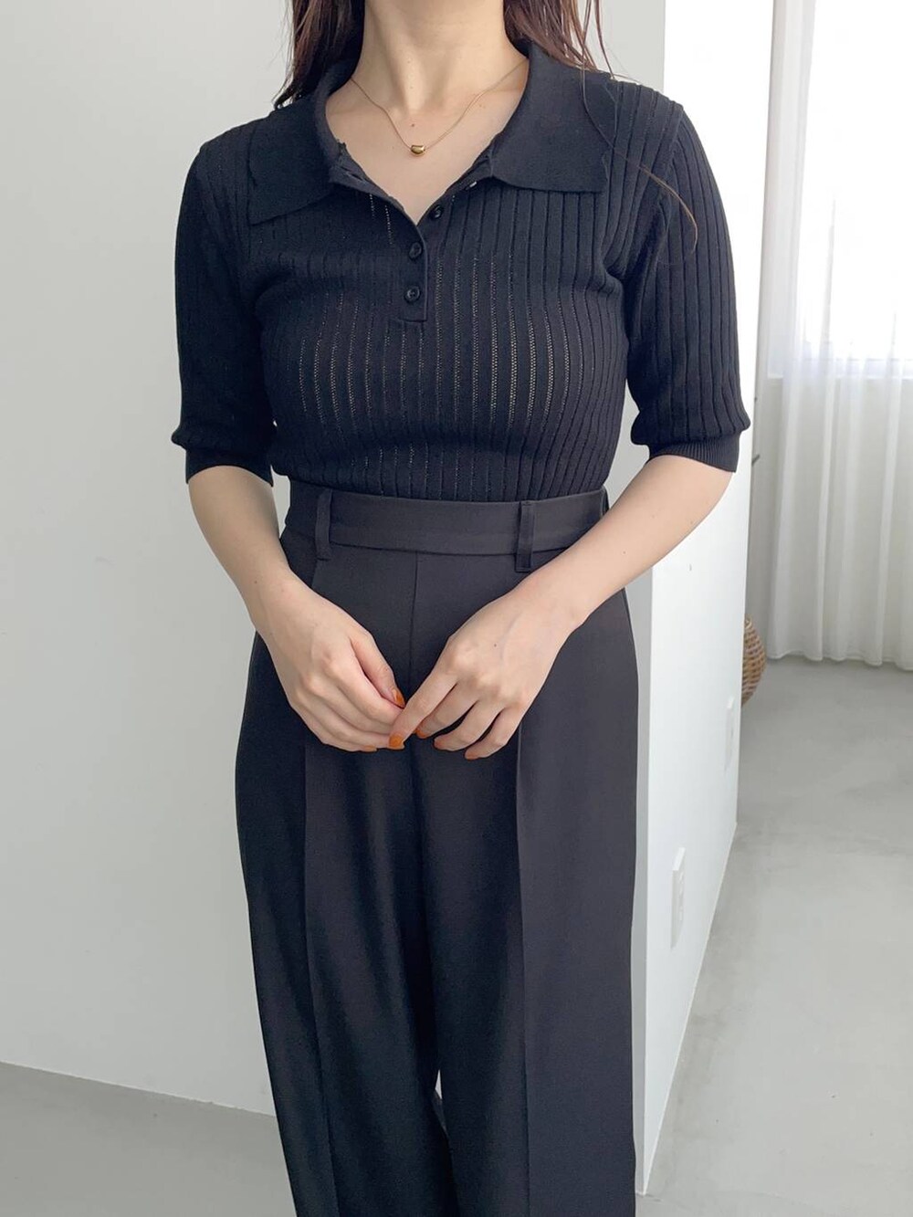 ブラック系のスラックス、ゴールド系のパンプス、グリーン系のスカートを着用したレディースの夏コーディネートの5枚目の写真