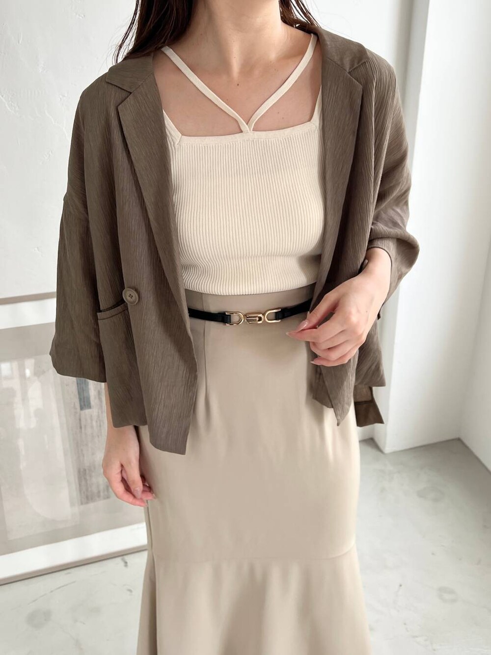 ブラック系のショルダーバッグ、ブラウン系のテーラードジャケット、ホワイト系のニット/セーターを着用したレディースの夏コーディネートの3枚目の写真