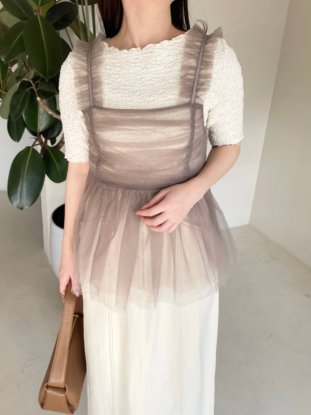 ホワイト系のスカート、ベージュ系のキャミソール、ホワイト系のTシャツ/カットソーを着用したレディースの春コーディネートの4枚目の写真