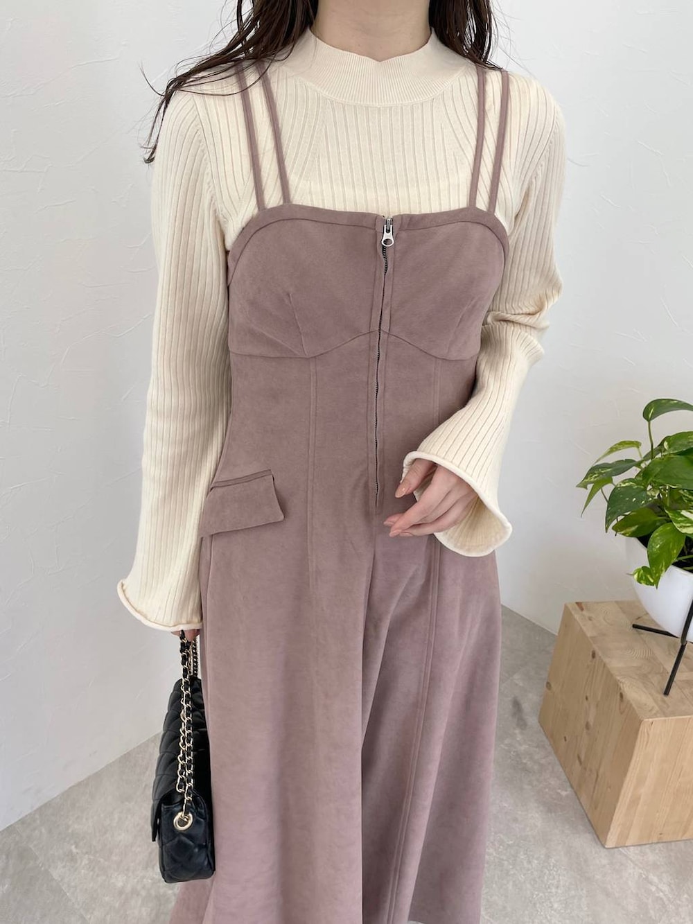 ピンク系のワンピース、ブラック系のショルダーバッグ、ホワイト系のニット/セーターを着用したレディースの冬コーディネートの3枚目の写真